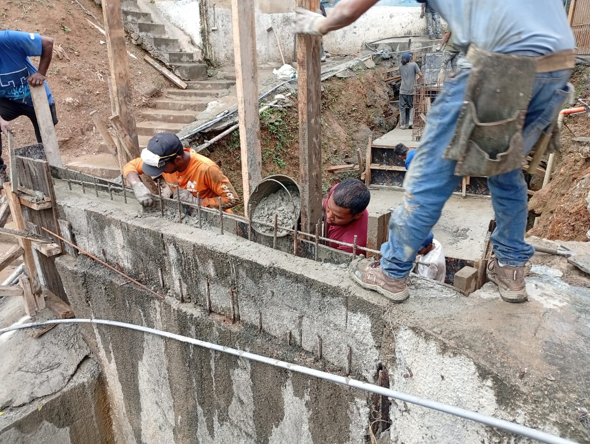 Cuadrilla vaciando concreto en un canal de drenaje