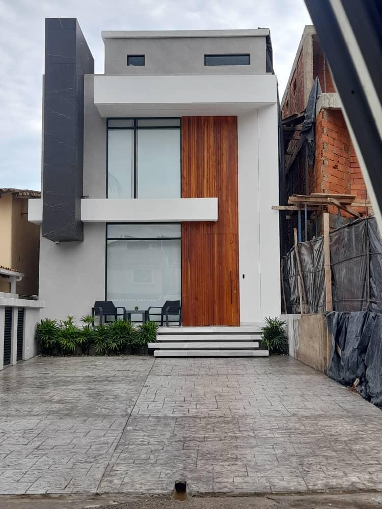 Acceso principal de vivienda con portón de madera